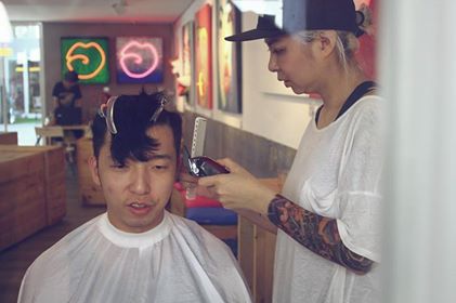 Megan, hairdresser cutting someone's hair at Flip Flop hostel